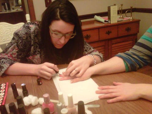 one woman doing another woman's nails at home 