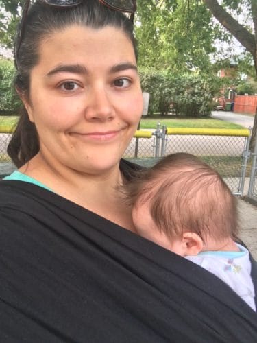 stay at home mom holding baby in carrier