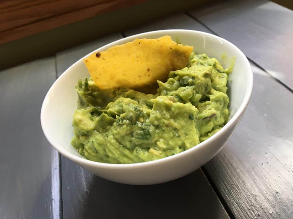 Chipotle guacamole in a bowl with a tortilla chip