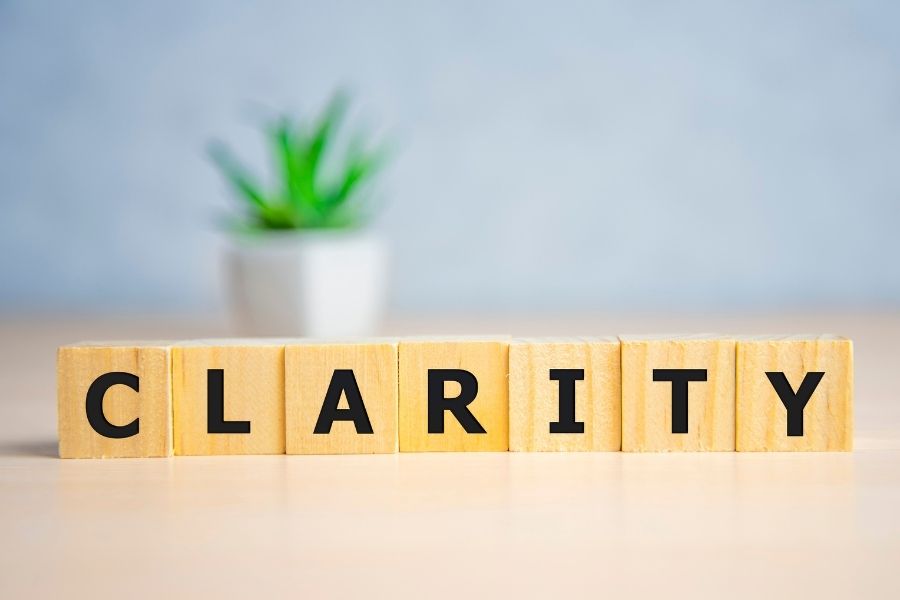 photo of wooden tiles spelling out clarity with a plant in the background