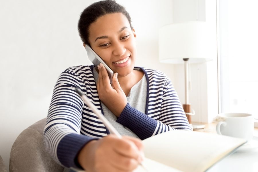 black woman on phone receiving coaching for moms